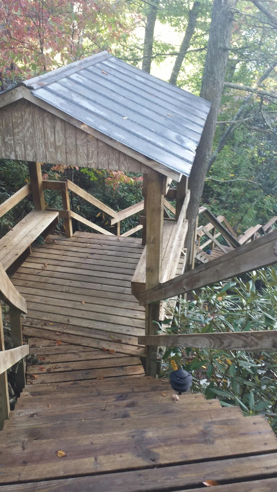 Metal roofed shelter over wooden steps on a wooded walkway — Skylight Repair & Installation work by our crew in Taylors Falls