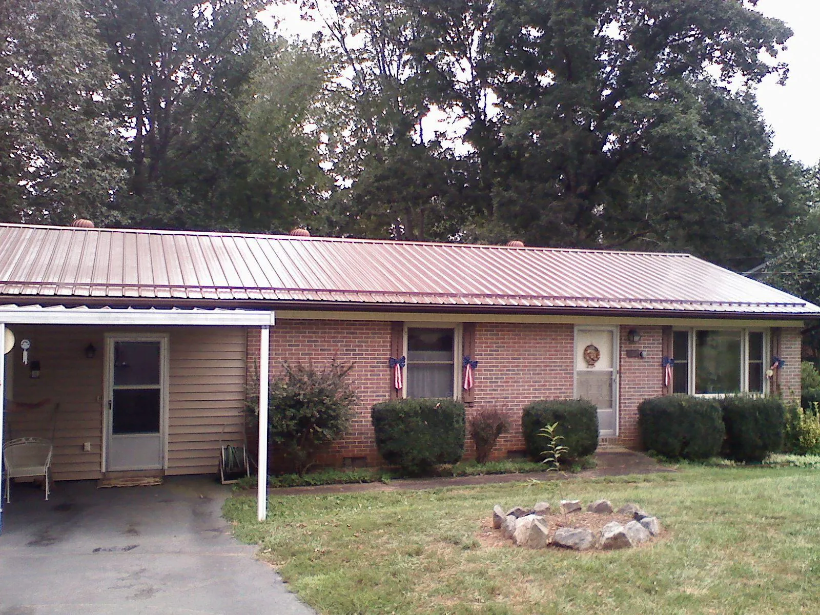 Bronze metal roof and carport on a brick ranch home — Roof Repair work by our crew in Taylors Falls