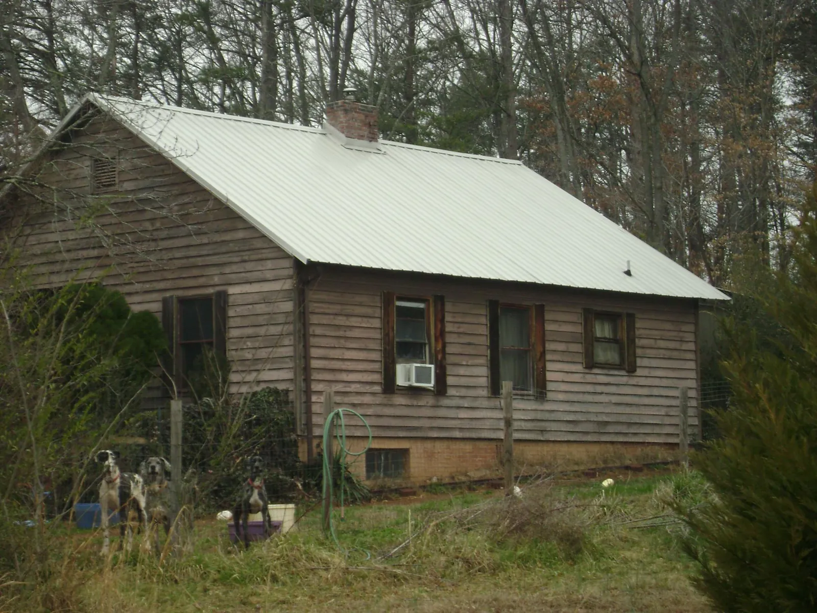 White metal roof on an old wood sided farmhouse, from a Metal Roof Installation job in Taylors Falls